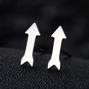 Macro side view of silver arrow earrings with polished stainless steel finish on black texture