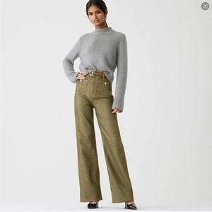 Macro shot of olive green wide-leg trousers with large front patch pockets and waist belt