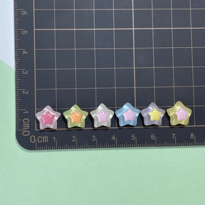 Close-up of colorful double-layer star resin beads on a measuring mat for DIY crafts