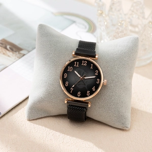 Detail view of fashion watch with black dial, rose gold case and magnetic mesh band