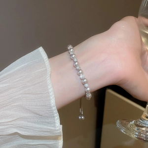 Gros plan d'un bracelet de perles ajustable avec zircons étincelants sur le poignet