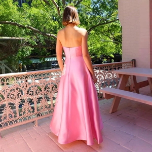 Rückenansicht eines rosa Satin-Abendkleids mit langer Schleppe im Freien