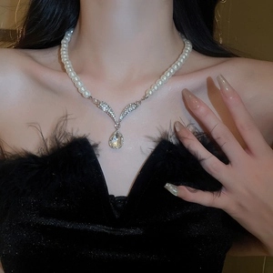 Detail of water drop crystal pendant with V-shaped diamond setting and round pearl strand