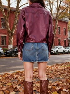 Vue arrière d'une veste de motard en cuir PU bordeaux portée avec une jupe en jean