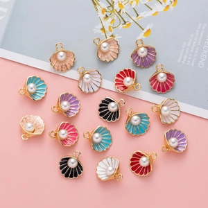 Detailed flat lay of alloy shell pendants with faux pearls for DIY jewelry making in various colors