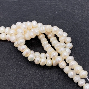 Macro detail of natural freshwater pearls with lustrous finish on a dark surface