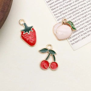 Detail of enamel fruit charms featuring strawberry, peach, and cherry shapes for jewelry making