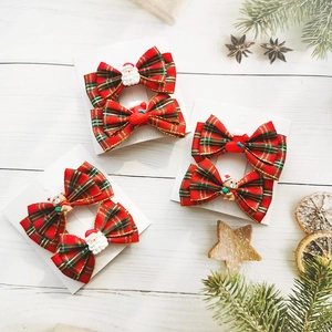 Detail of Christmas hair clips with red plaid bows and cute resin Santa charms