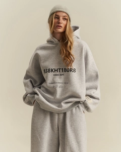 Dettaglio felpa grigia oversize con scritte limited edition e berretto in maglia