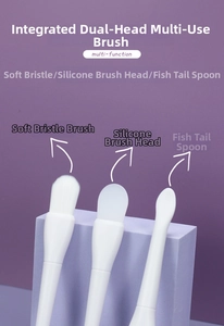 Detailed view of dual-ended facial mask brush with soft bristles and silicone fish tail spoon