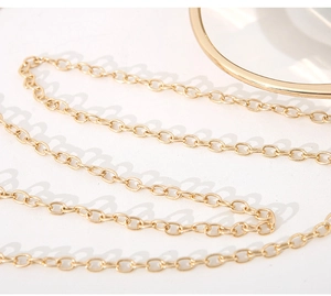 Macro shot of elegant golden oval chain strap for women's luxury evening handbag