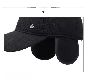 Detailed view of winter baseball cap with plush ear flaps and side metal badge