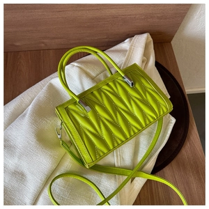 Detail of lime green ruched tote bag with quilted texture and silver hardware