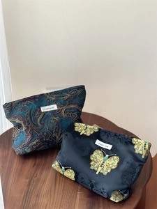 Close-up of vintage jacquard makeup bags with gold embroidery and paisley patterns