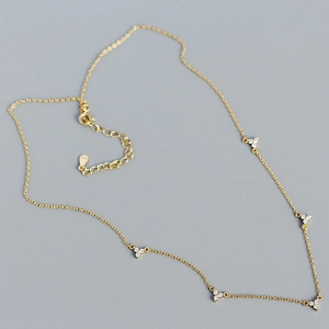 Détail du collier doré avec trèfles en zircon et fermoir mousqueton ajustable