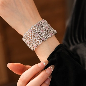 Detailed view of silver cuff bracelet with pink gemstones and pavé zircon stones