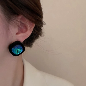 Détail de boucles d'oreilles carrées vintage avec une pierre précieuse à facettes
