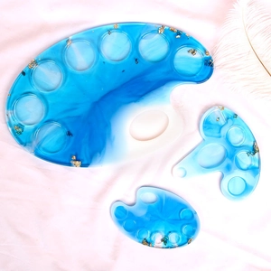 Artistic blue and white resin palette set with gold leaf edges on white silk background