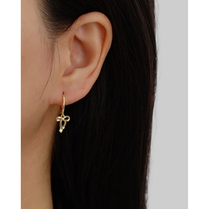 Elegant gold bow pendant earrings on model featuring a minimalist ribbon knot design