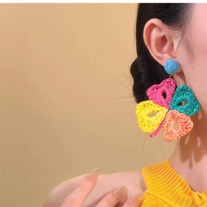 Detailed close-up of handmade raffia flower earrings with colorful woven petals