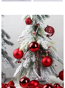 Detail of red Christmas balls in matte, glossy, and glitter finishes on snowy branches