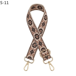 Close-up of bohemian canvas strap with brown floral pattern and gold metal buckles