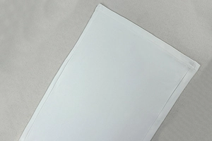Macro detail of high-quality double stitching on white halter two-piece set fabric