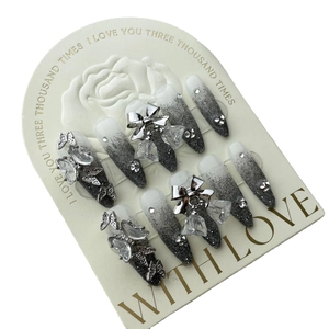 Handmade press-on nails with silver butterfly charms, gradient glitter, and rhinestones