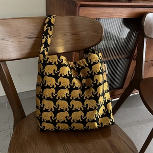 Détail du tissu jacquard d'éléphant doré et de l'étiquette sur le sac à bandoulière