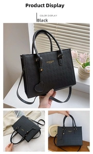 Detail of black quilted tote bag with golden hardware and chic heart pendant
