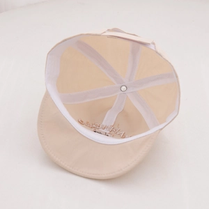 Internal view of the beige baby sun hat showing six-panel stitching and embroidery detail
