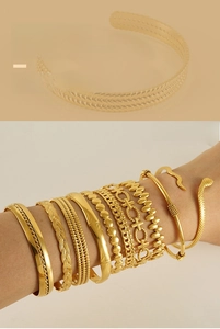 Stacked set of golden adjustable C-shaped bracelets with snakeskin and polished textures
