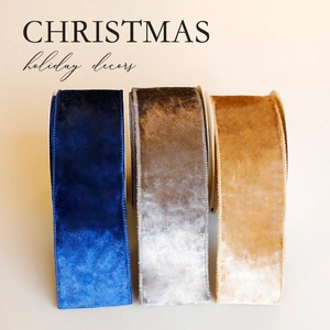 Luxurious velvet Christmas ribbons in navy blue, silver, and gold spools for holiday decor