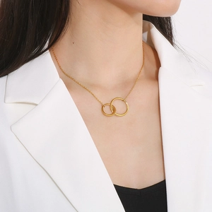 Detail showing interlocking gold double rings necklace on model in white blazer