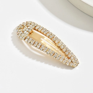 Close-up of golden metal teardrop hair clip with shimmering rows of inlaid rhinestones