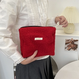 Detail van de rode fleece make-uptas met zachte textuur en stevige ritssluiting