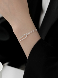 Close-up of S925 sterling silver chain bracelet with U-shaped lock and rope texture