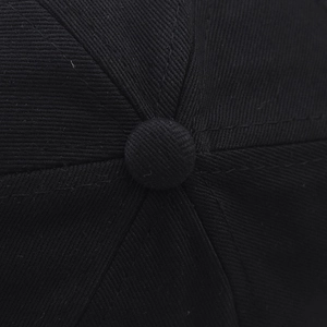 Detailed top view of a black cotton baseball cap showing twill texture and crown button