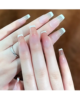Close-up of nude pink gradient long coffin nails with classic white French tips