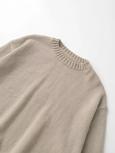 Detail of beige crew neck knitted sweater featuring premium ribbed collar and drop shoulder