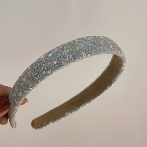 Close-up of silver sequin headband with glitter finish and brown inner lining