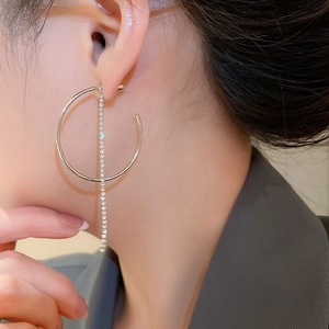 Dettaglio degli orecchini a cerchio con nappe in argento e strass su modella