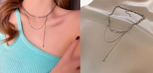 Detail of silver double-layer titanium necklace with paperclip design and long bead pendant