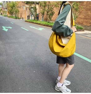 Outdoor street shot of ginger yellow large capacity oxford cloth crescent crossbody bag