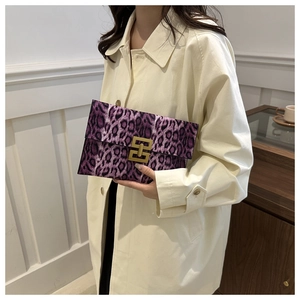 Detail of purple leopard print envelope clutch with gold metal buckle on a trench coat