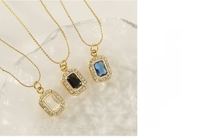 Macro detail of rectangular zircon pendants with double-layer pavé diamonds on gold chains