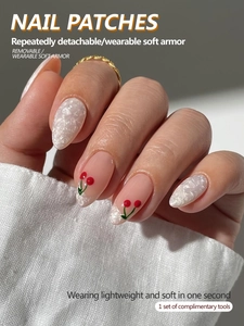 Close-up of white marble and cherry pattern press-on nails with complimentary tool set