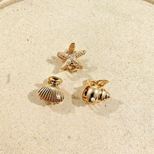 Detail of golden mini starfish, shell, and conch hair clips with delicate pearls