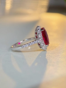 Side view detail of S925 silver ring featuring red oval gemstone and pavé zircon stones