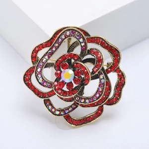 Macro shot of spider lily brooch with red rhinestones and vintage gold metal finish